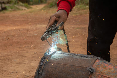 Midsection of man welding metal