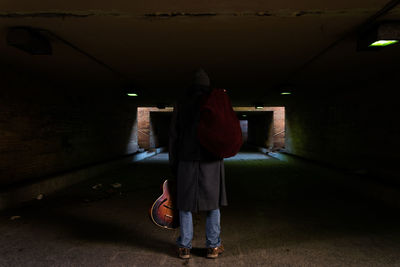 Rear view of man standing in underground walkway