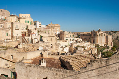 Buildings in town against clear blue sky