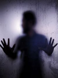 Shadow of person hand on glass wall