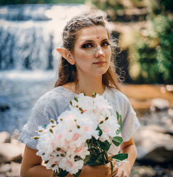 Portrait of young woman holding flower