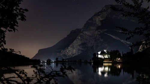 Toblino castle on lake toblino in the evening under the starry sky and mountain