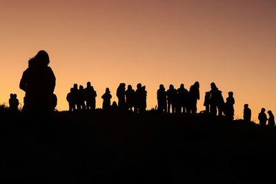 Silhouette people against clear sky during sunset