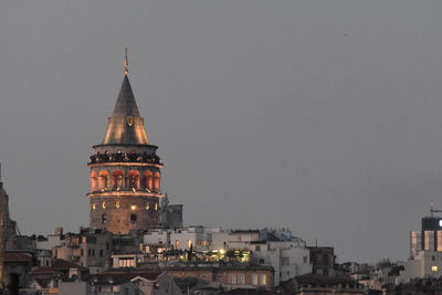 Illuminated buildings in city against sky