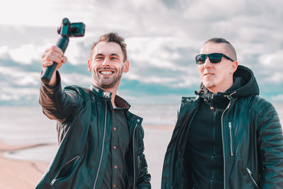 Portrait of smiling young man photographing