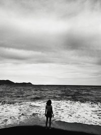 Rear view of woman standing on beach