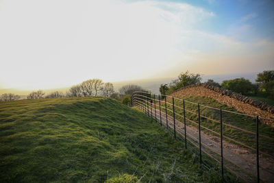 Fence on field against sky