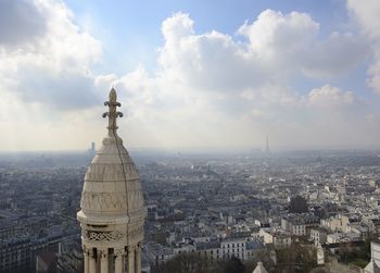 High angle view of city buildings against cloudy sky