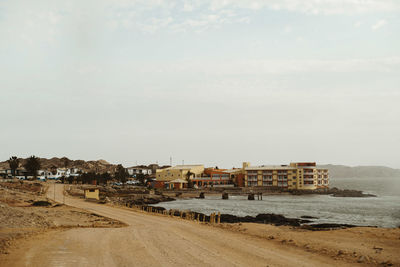 Buildings by sea against sky in city