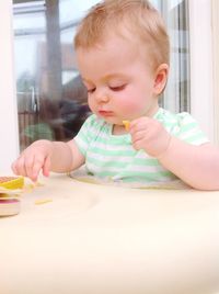 Cute baby eating food at home