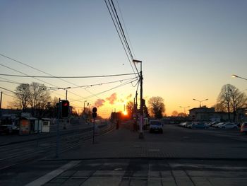 Cars on road against sky during sunset