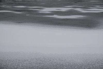 Close-up of snow on sand at beach