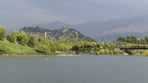 Scenic view of river by mountains against sky