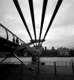 Bridge over river against cloudy sky