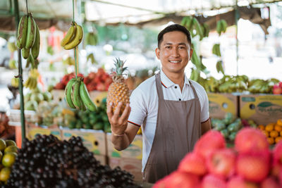 Portrait of young woman standing at market