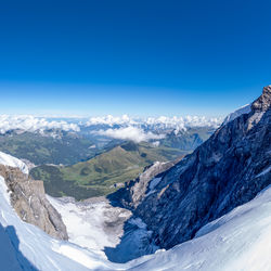 Scenic view of snowcapped mountains against blue sky