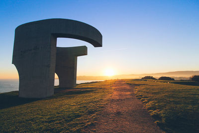 Sculpture at sunrise.  elogio del horizonte by eduardo chillida, year 1990 in the city of gijon.