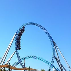 Low angle view of ferris wheel against blue sky