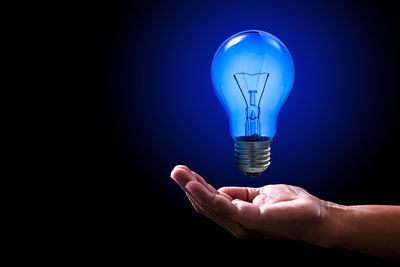 Close-up of light bulb against blue background