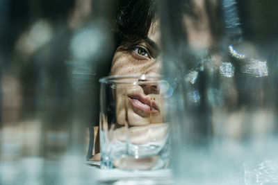 Portrait of woman looking away, glass reflection
