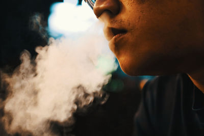 Close-up of man emitting smoke