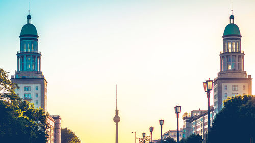 Low angle view of communications tower and towers against clear sky