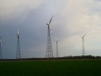 Low angle view of electricity pylon against sky during sunset