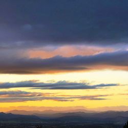 Scenic view of dramatic sky over silhouette landscape