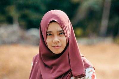 Close-up portrait of smiling young woman wearing hijab