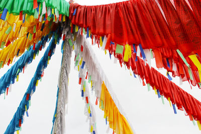 Low angle view of prayer flags hanging against sky