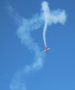 Low angle view of airplane flying against blue sky