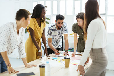 Colleagues working together at desk in office discussing papers