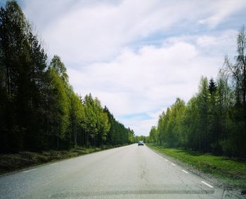 Road amidst trees against sky