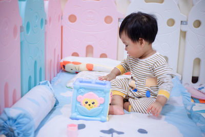 Boy with toy on bed