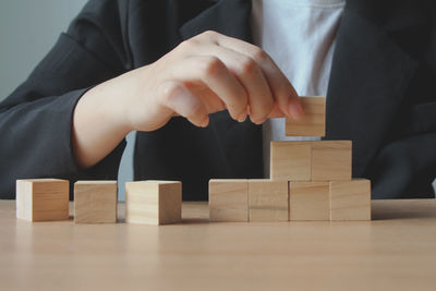 Midsection of businessman playing block toy blocks