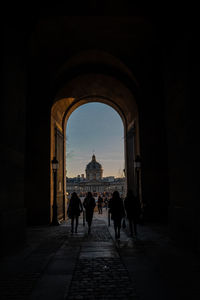 Rear view of people walking in historical building