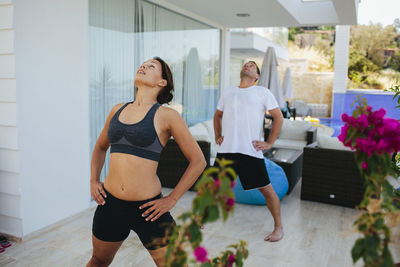 Young couple exercising on veranda