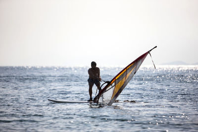 Windsurfer pulling sail out of the water