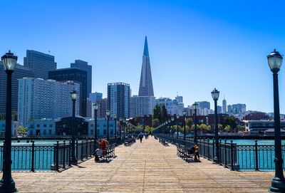 Pier seven against transamerica pyramid amidst buildings against clear sky on sunny day