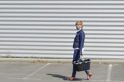 Full length of woman walking on road in city