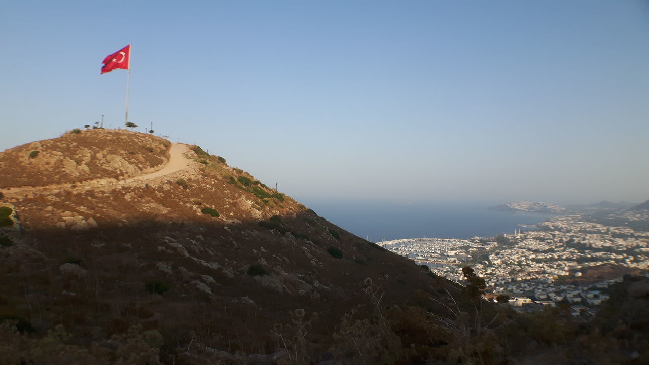 SCENIC VIEW OF SEA AND MOUNTAIN AGAINST CLEAR SKY