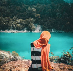 Rear view of man standing by lake