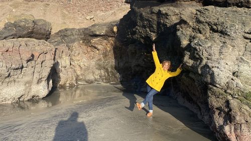 Woman standing on rock by water