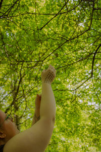 Low section of woman against tree