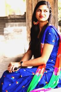 Portrait of young woman sitting outdoors