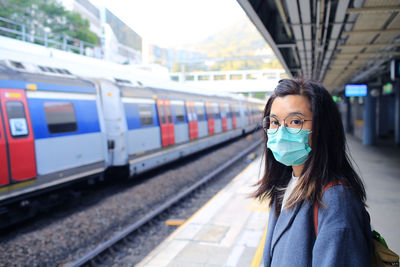 Portrait of woman standing at railroad station