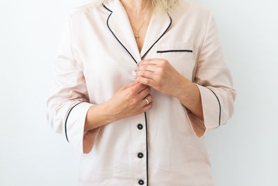 Midsection of doctor holding stethoscope against white background