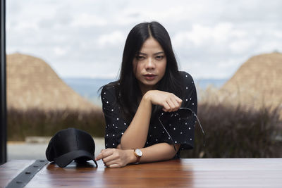 Portrait of young woman sitting on table