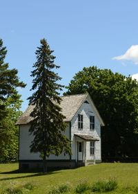 House amidst trees and buildings against sky