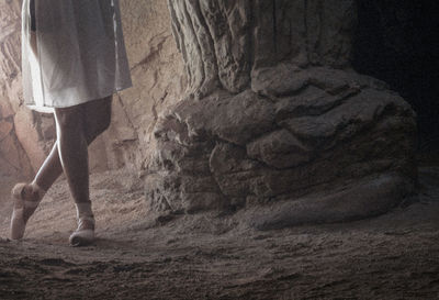 Low section of woman standing on rock